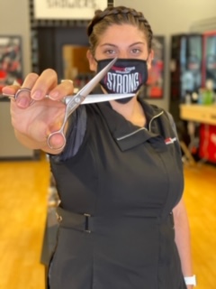 Sport Clips Stylist holding shears and wearing her mask to promote the Sport Clips Clean Certified Program